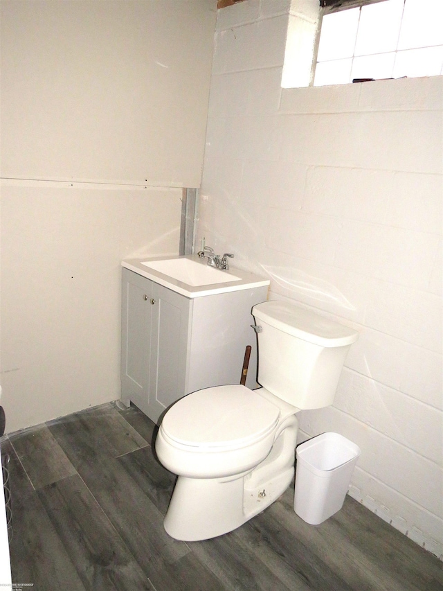 half bathroom featuring toilet, vanity, and wood finished floors