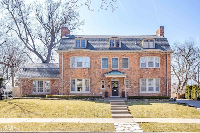 view of front of house with a front lawn, a high end roof, brick siding, and a chimney