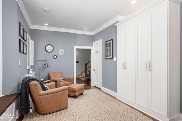 living area featuring baseboards, light wood-style flooring, recessed lighting, ornamental molding, and stairs