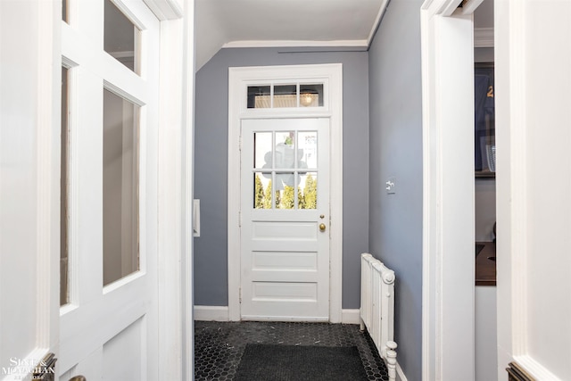 doorway with radiator, baseboards, and vaulted ceiling