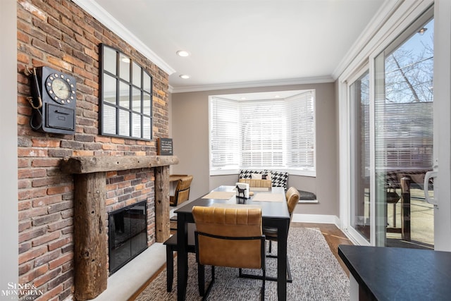 dining room featuring recessed lighting, a brick fireplace, crown molding, and baseboards