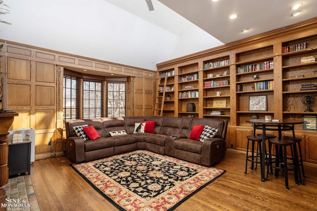 living area featuring lofted ceiling, wood finished floors, and wood walls