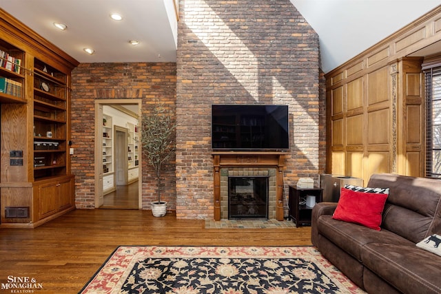 living area with visible vents, built in features, wood finished floors, recessed lighting, and a fireplace