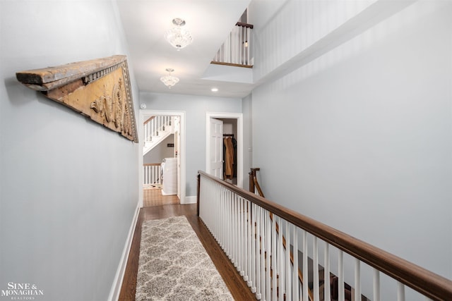 corridor featuring wood finished floors, recessed lighting, an upstairs landing, and baseboards