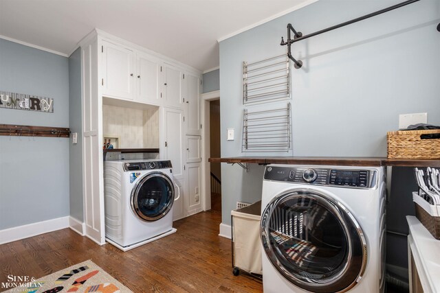 washroom featuring baseboards, dark wood finished floors, cabinet space, crown molding, and washer and clothes dryer