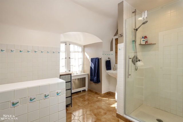 bathroom with tile patterned floors, tiled shower, and tile walls