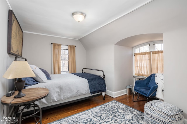 bedroom with baseboards, wood finished floors, and vaulted ceiling