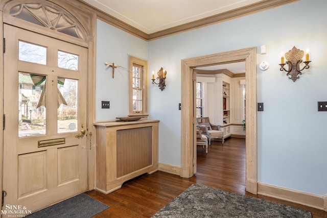 foyer entrance with dark wood-type flooring, baseboards, and ornamental molding