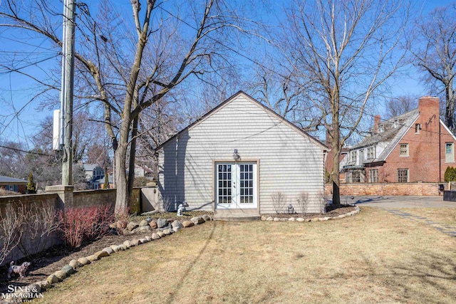 rear view of house with french doors, a yard, and fence