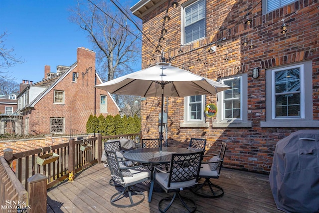 deck with outdoor dining space and grilling area