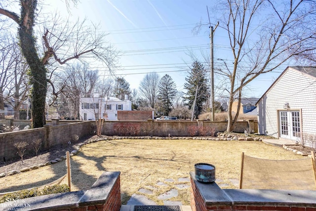 view of yard with french doors and a fenced backyard