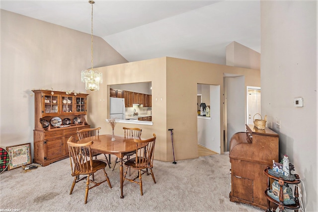 dining space with lofted ceiling, a notable chandelier, and light carpet