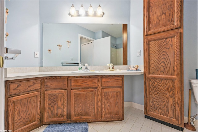 bathroom featuring toilet, vanity, and tile patterned flooring