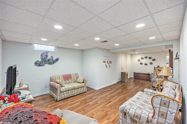 living room featuring visible vents, baseboards, and wood finished floors