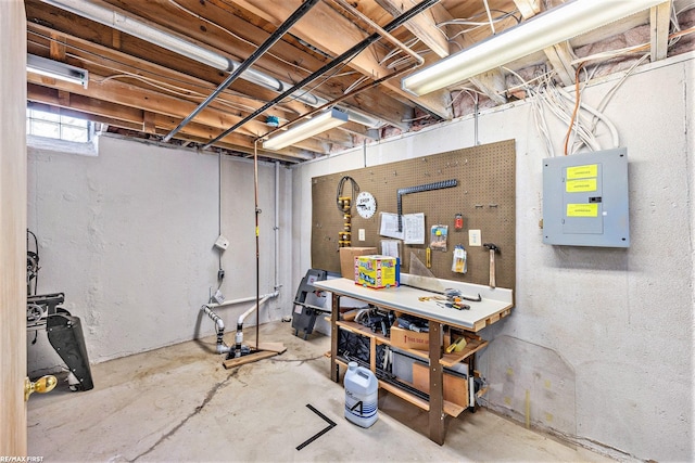 basement with electric panel and a workshop area