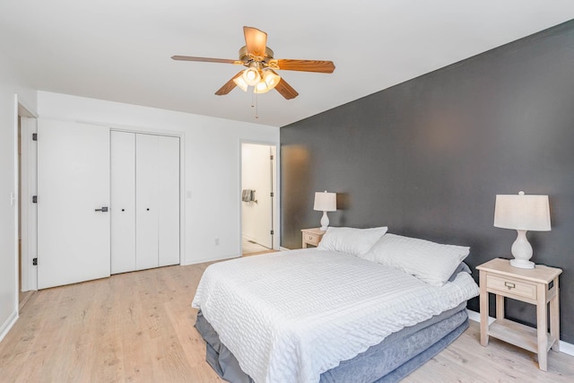 bedroom with a closet, baseboards, a ceiling fan, and light wood finished floors