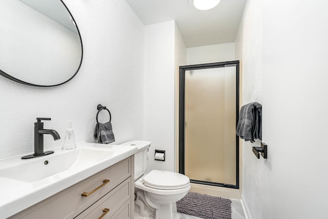 full bathroom with vanity, toilet, a shower stall, and a textured wall