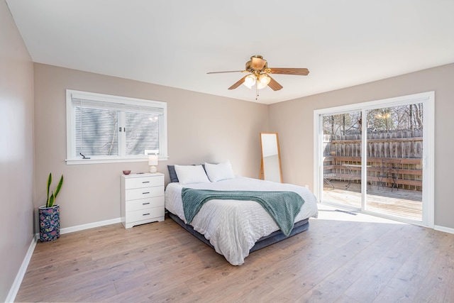 bedroom featuring access to outside, multiple windows, and light wood finished floors