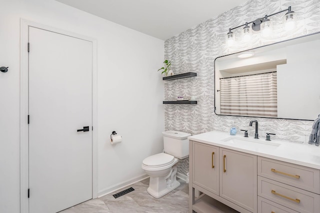 full bath with vanity, baseboards, visible vents, wallpapered walls, and toilet