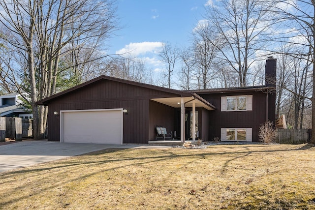 view of front of house featuring fence, a front yard, a chimney, a garage, and driveway