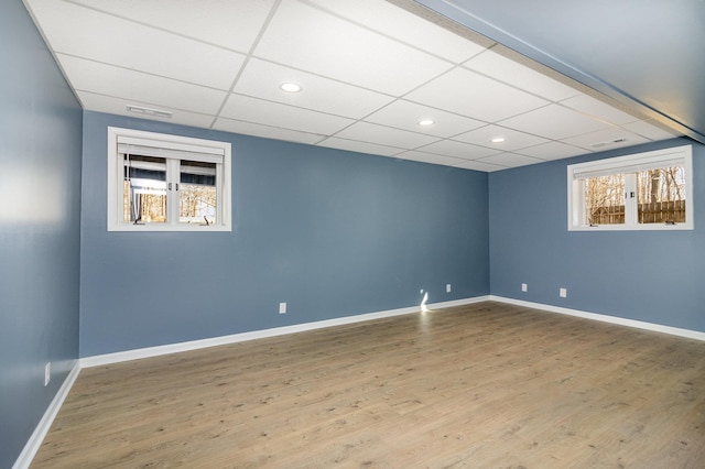 unfurnished room with plenty of natural light, wood finished floors, and baseboards