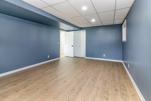 unfurnished room featuring recessed lighting, wood finished floors, baseboards, and a drop ceiling