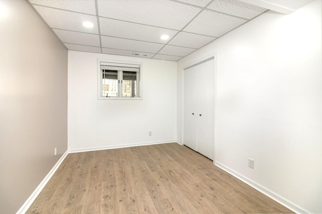 unfurnished room featuring baseboards, a paneled ceiling, visible vents, and light wood-style flooring