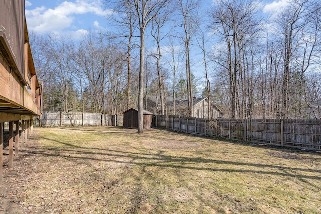 view of yard with a storage unit, an outbuilding, and a fenced backyard