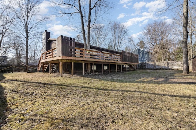 rear view of property featuring a wooden deck, stairs, a chimney, a yard, and a fenced backyard