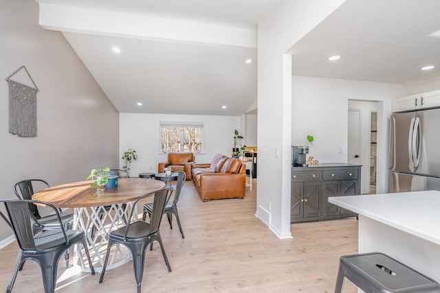 dining room featuring vaulted ceiling with beams, recessed lighting, baseboards, and light wood finished floors