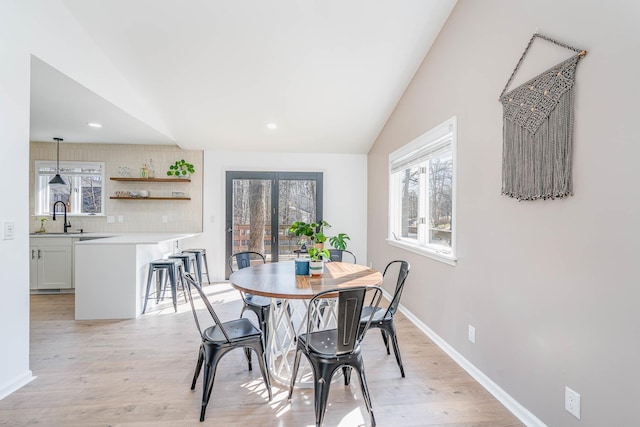 dining space featuring recessed lighting, baseboards, vaulted ceiling, and light wood finished floors