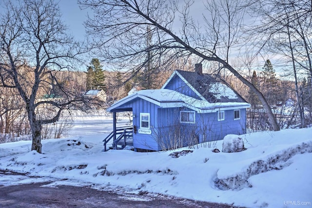 exterior space featuring board and batten siding and a chimney