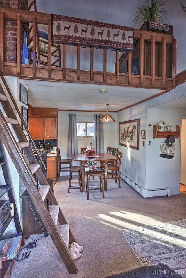 carpeted dining room featuring stairway and a baseboard radiator