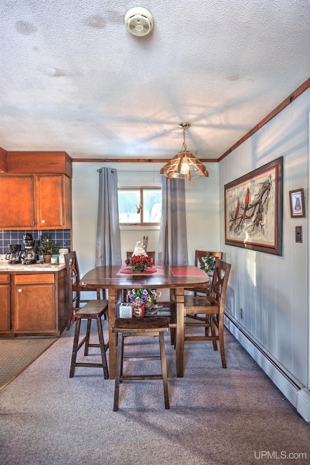 dining room featuring carpet flooring, a textured ceiling, crown molding, and a baseboard radiator