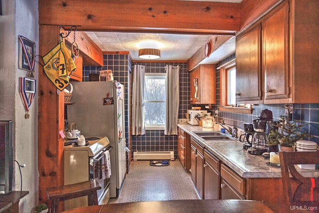 kitchen with a sink, backsplash, electric range oven, brown cabinetry, and a baseboard radiator