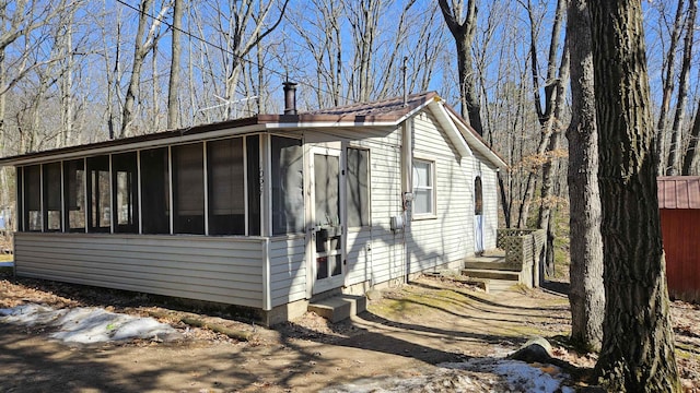 view of property exterior featuring a sunroom