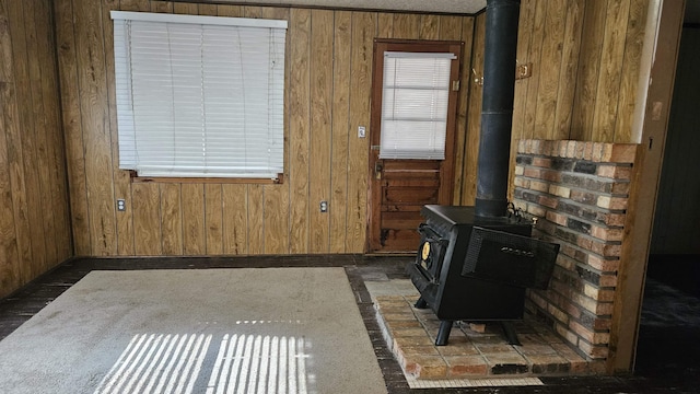 doorway to outside with a wood stove and wooden walls