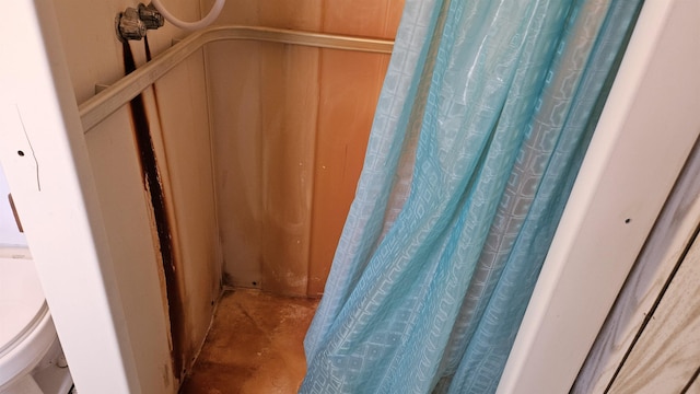 interior details featuring a shower with shower curtain and concrete flooring