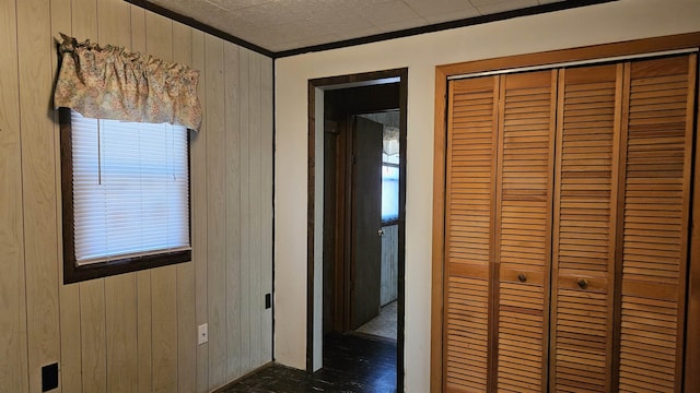 corridor featuring crown molding and wood walls