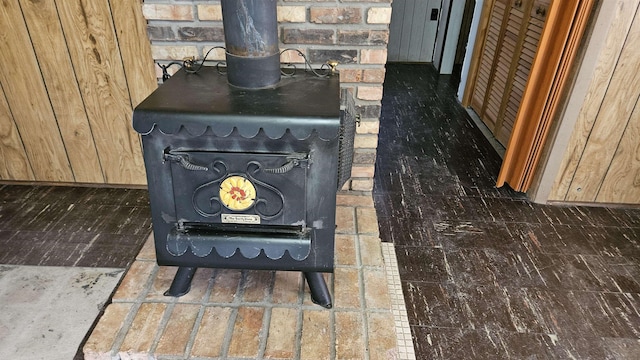 details with baseboards, wooden walls, and a wood stove