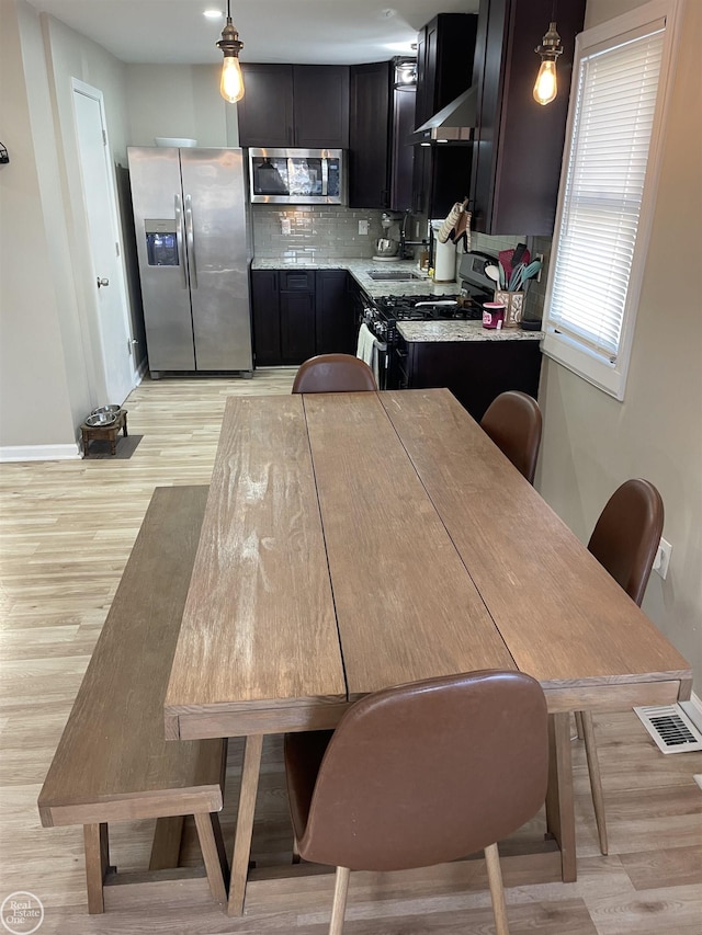 dining room with visible vents, baseboards, and light wood-style flooring