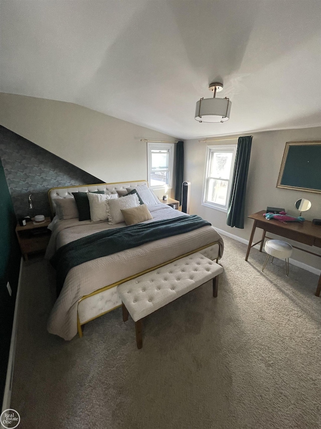 carpeted bedroom featuring lofted ceiling and baseboards