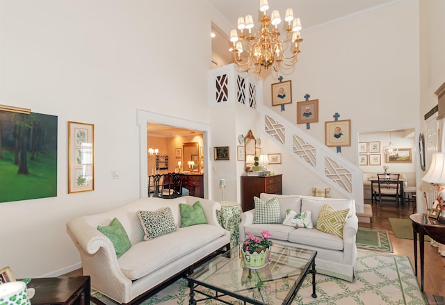 living area featuring a notable chandelier, stairs, and wood finished floors