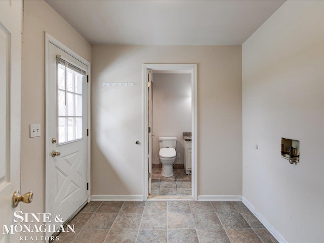 interior space featuring toilet and baseboards