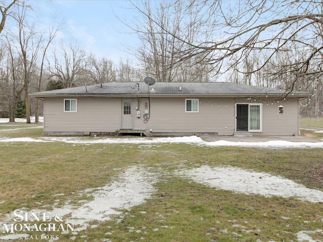 back of property featuring a yard, metal roof, dirt driveway, and entry steps