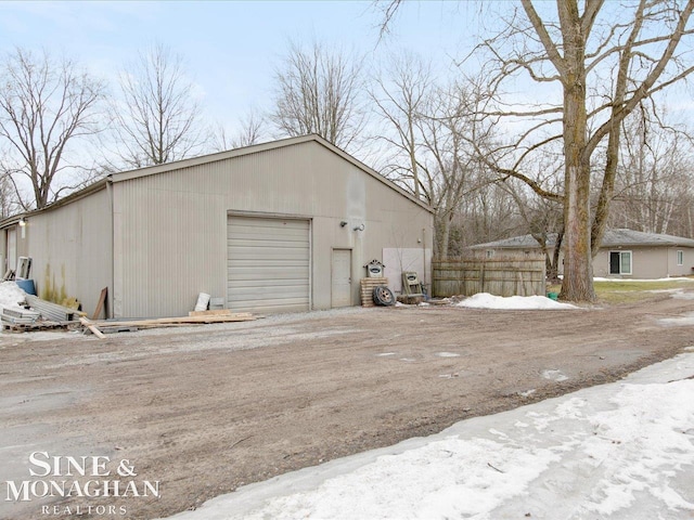 detached garage with fence and driveway