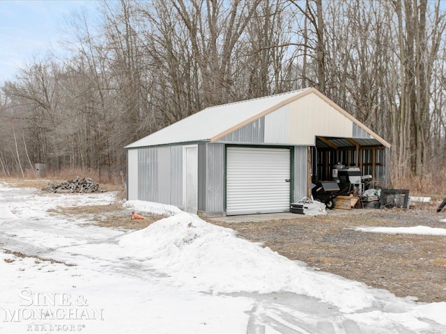 snow covered garage featuring a detached garage