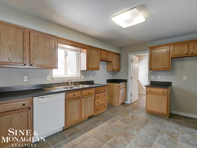 kitchen featuring dark countertops, dishwasher, baseboards, and a sink