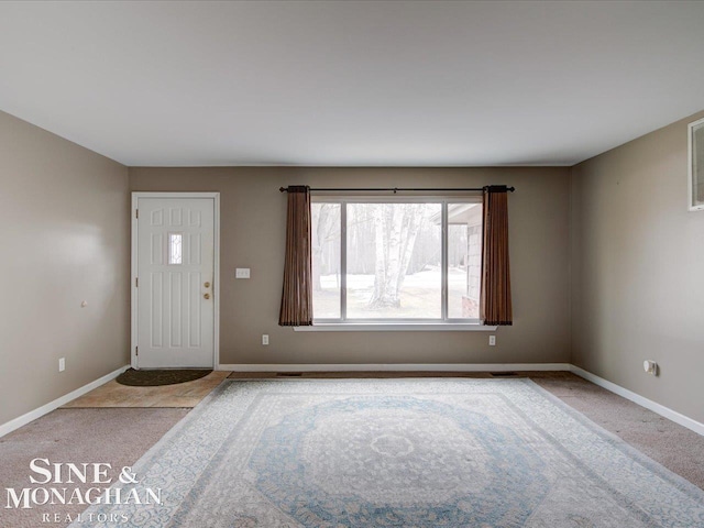 foyer entrance with carpet flooring and baseboards