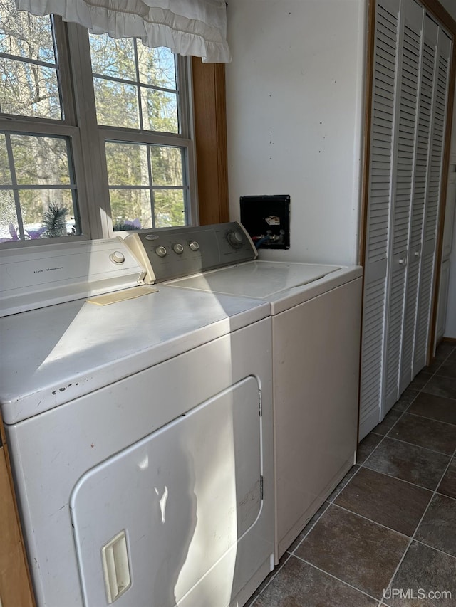 laundry room featuring laundry area, washing machine and dryer, and dark tile patterned flooring